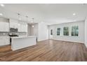 Open-concept kitchen and living area with white cabinets, an island, stainless steel appliances, and wood-look flooring at 622 Brittany Ct, Durham, NC 27703