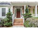 Inviting front porch with stone accents and white railing, framed by manicured landscaping and a wood door at 1620 Dunn Rd, Raleigh, NC 27614