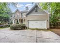 Spacious two-car garage featuring neutral siding and a concrete driveway surrounded by lush landscaping at 1620 Dunn Rd, Raleigh, NC 27614