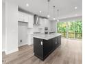 Contemporary kitchen with stainless steel appliances, white cabinets, island and sliding glass door to back deck at 4505 Mint Leaf Ln, Raleigh, NC 27612