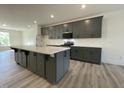 Bright kitchen boasts a large island, gray cabinets, modern appliances, stylish countertops, and wood flooring at 476 Traditions Grande Blvd # 33, Wake Forest, NC 27587