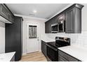 Contemporary kitchen boasts sleek gray cabinetry, subway tile backsplash, and access to the outdoors at 109 Lone Star Dr, Louisburg, NC 27549