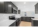 Modern kitchen features stainless steel appliances, gray cabinets, and white quartz countertops at 109 Lone Star Dr, Louisburg, NC 27549