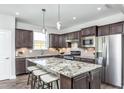 Modern kitchen with granite island, stainless steel appliances, and dark cabinetry at 2513 Shorebird Dr, Fuquay Varina, NC 27526
