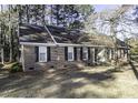Traditional brick home with black shutters, complemented by natural surroundings and mature trees at 3540 Chelsea Dr, Rocky Mount, NC 27803