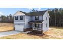 Two-story home with blue siding, an attached two-car garage, and a covered porch at 9133 Phoenix Ct, Spring Hope, NC 27882