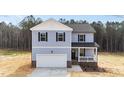 Charming two-story home with blue siding, white trim, and an attached two-car garage at 9133 Phoenix Ct, Spring Hope, NC 27882