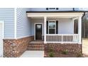Close up of front door and porch with brick foundation and white railings at 9133 Phoenix Ct, Spring Hope, NC 27882