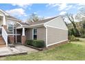 Charming townhouse exterior with a brick and siding facade, complimented by lush green lawn and mature trees at 1320 S State Street # D, Raleigh, NC 27610