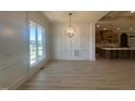 Bright dining room featuring a large window, decorative wainscoting, and a modern chandelier at 142 Batten Hill Ln, Selma, NC 27576