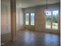 The bright foyer features decorative wainscoting, light wood floors, and elegant glass front doors at 142 Batten Hill Ln, Selma, NC 27576