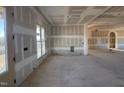 Open-concept living area with large windows, arched doorways, and unfinished walls awaiting finishing touches at 142 Batten Hill Ln, Selma, NC 27576