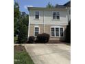 This two-story home has a neutral exterior with a concrete driveway and neatly trimmed landscaping at 526 Elm Ave, Wake Forest, NC 27587