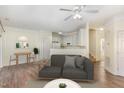 A modern living room with a cozy gray sofa, hardwood floors, and an adjacent kitchen area at 526 Elm Ave, Wake Forest, NC 27587