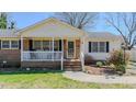 Close-up of the home's charming front porch with rocking chairs and brick steps at 2434 Orice St, Burlington, NC 27215