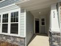Inviting entryway with a covered porch and stone veneer on the support columns of the townhome at 424 La Maison Ave # 9, Wendell, NC 27591