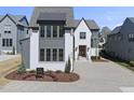 Beautiful two-story home featuring white brick, grey trim, a paved driveway, and lush landscaping at 3410 Bradley Pl, Raleigh, NC 27607