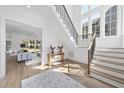 Bright foyer with hardwood floors, staircase, white walls, and an area rug near an open doorway at 3410 Bradley Pl, Raleigh, NC 27607