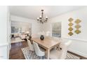 Bright dining room featuring modern chandelier, stylish table set, and seamless view to living room at 42 Oakwood Dr, Chapel Hill, NC 27517