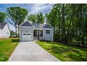 Beautiful new home with lush green lawn, complemented by mature trees and landscaping at 235 Sequoia Dr, Louisburg, NC 27549