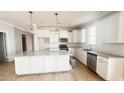 Bright kitchen featuring granite counters, herringbone tile backsplash, stainless appliances, and a large island at 235 Sequoia Dr, Louisburg, NC 27549