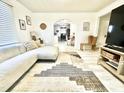 Bright living room with a white couch, modern rug, and an arched entryway to the kitchen at 507 N Mack St, Creedmoor, NC 27522