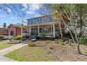 Two-story blue house with a wide front porch, garden and mature trees at 417 Elm St, Raleigh, NC 27604