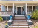 Inviting front porch with decorative columns and colorful planters leading up to the main entrance at 417 Elm St, Raleigh, NC 27604