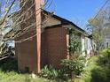 This is the exterior of a brick house with a chimney and a small garden area with plants at 2219 Fitzgerald Ave, Durham, NC 27707