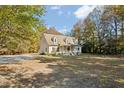 Classic home featuring a large front yard, mature trees, and a welcoming front porch at 7039 Old 421 Rd, Liberty, NC 27298