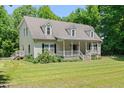 A charming two-story home featuring a front porch, complemented by a well-maintained lawn at 7039 Old 421 Rd, Liberty, NC 27298
