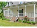 Charming home entrance with a welcoming porch, staircase, and flower landscaping at 7039 Old 421 Rd, Liberty, NC 27298