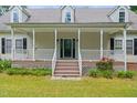 Home with a charming front porch and steps, enhanced by flower landscaping at 7039 Old 421 Rd, Liberty, NC 27298