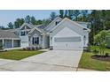 Charming home showcasing stone accents, white siding, two-car garage and well-maintained landscaping at 7529 Percussion Dr, Apex, NC 27539