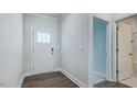 Bright foyer featuring wood floors, access to a bathroom and a doorway leading to other parts of the home at 7529 Percussion Dr, Apex, NC 27539