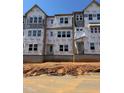 Unfinished exterior showcasing the building's framework with multiple windows and Tyvek HomeWrap at 1204 Holding Village Way, Wake Forest, NC 27587