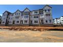Unfinished exterior showcasing the building's framework with multiple windows and Tyvek HomeWrap at 1204 Holding Village Way, Wake Forest, NC 27587
