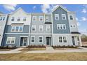 Charming townhomes featuring varied blue and gray tones, accented by white trim and lush landscaping at 1204 Holding Village Way, Wake Forest, NC 27587
