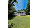 Single story home with a welcoming covered front porch, set among mature trees and lush green grass at 135 Weatherbend, Pittsboro, NC 27312