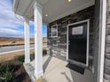 Front porch with stone accents, support columns, and a solid front door at 150 Steppe Way, Garner, NC 27529