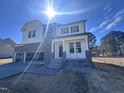 Beautiful two-story home with stone accents, a welcoming front porch, and a spacious three-car garage at 199 Shelby Meadow Ln, Angier, NC 27501
