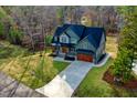 A stunning aerial view showcasing the beautiful home, expansive driveway, and lush greenery of the property at 414 S Sb Harrison Ln, Henderson, NC 27537
