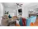Cozy living room featuring hardwood floors, a ceiling fan, and fireplace with mounted television at 6512 Johnsdale Rd, Raleigh, NC 27615