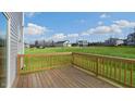 Wooden deck overlooking a large grassy backyard with a view of neighboring houses at 70 Scenic Rock Dr, Youngsville, NC 27596