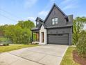 Charming gray home features a well-manicured lawn, a two-car garage, and inviting front porch at 734 S State St, Raleigh, NC 27601