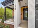 Close-up of the home's front entrance featuring a white brick facade, and a cozy porch area at 734 S State St, Raleigh, NC 27601