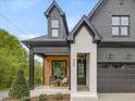 Inviting front porch with wood accent wall, seating, and stylish black trim, adjacent to the garage entrance at 734 S State St, Raleigh, NC 27601