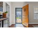 Ornate wooden front door with a glass storm door and a rug at 151 Ottawa Dr, Louisburg, NC 27549