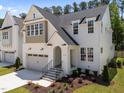 Beautiful two-story home featuring a white brick facade, a two-car garage, and manicured landscaping at 1721 Burnette Garden Path, Raleigh, NC 27612