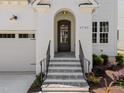 Inviting front entrance with an arched doorway, stone steps, and wrought iron railings at 1721 Burnette Garden Path, Raleigh, NC 27612